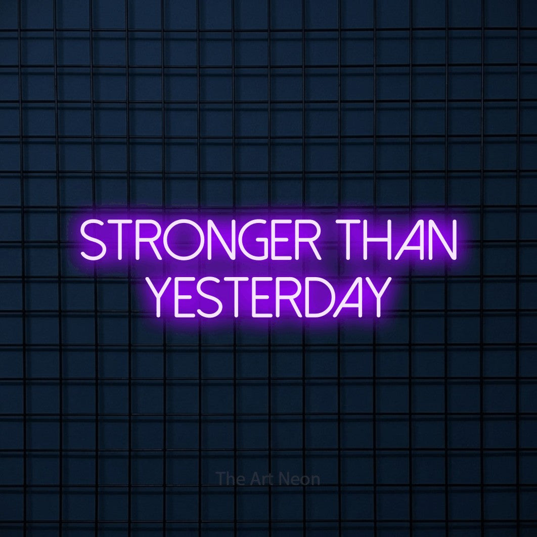 Purple LED neon sign reading "Stronger Than Yesterday" against a dark blue tiled wall