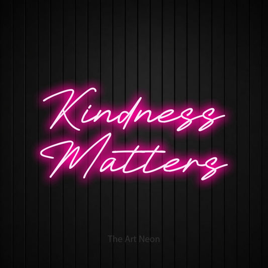 Enseigne néon à DEL à lumière rose vif, affichant « Kindness Matters » sur un mur noir à lattes verticales