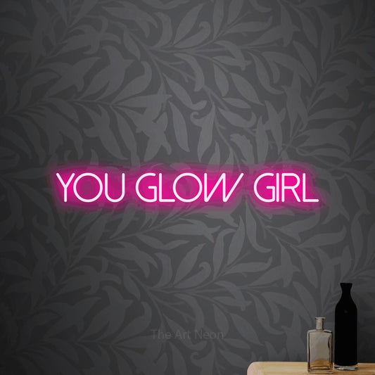 Enseigne néon à DEL à lumière rose vif, affichant « You Glow Girl » sur un papier peint floral gris pâle
