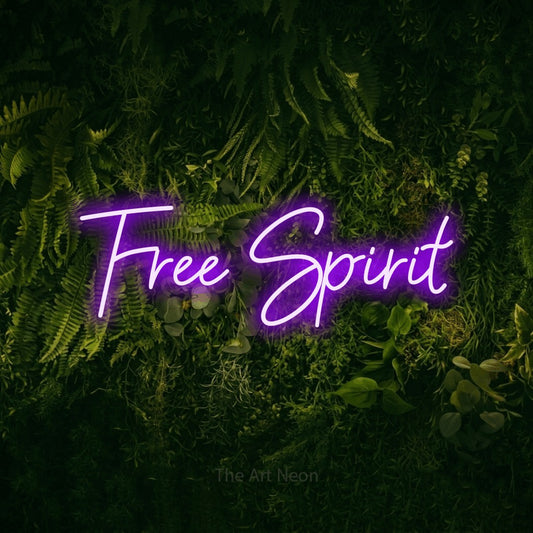 Enseigne néon à DEL à lumière violette, de style manuscrit, affichant « Free Spirit » sur un mur vert couvert de mousse