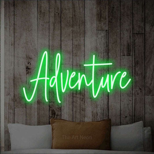 Enseigne néon à DEL à lumière verte, de style manuscrit, affichant « Adventure » sur un mur de bois blanchi