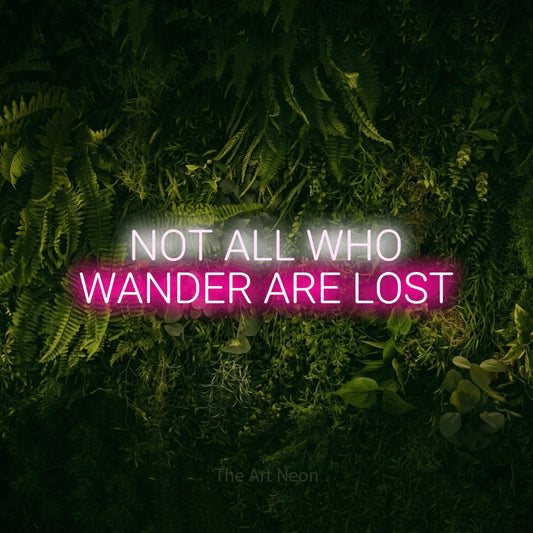 Hot pink and cool white LED neon sign reading "Not All Who Wander Are Lost" against a moss-covered green wall