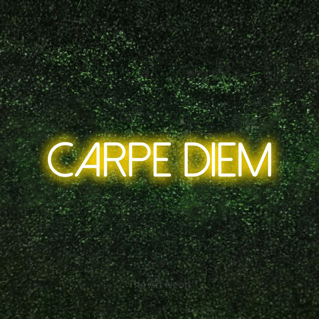 Yellow LED neon sign reading "Carpe Diem" against a textured green moss wall