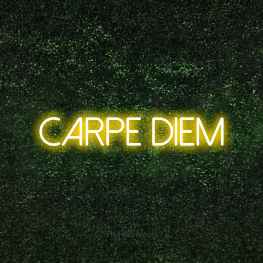 Yellow LED neon sign reading "Carpe Diem" against a textured green moss wall