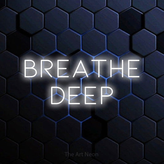 Cool white LED neon sign reading "Breathe Deep" against a blue hexagonal wall