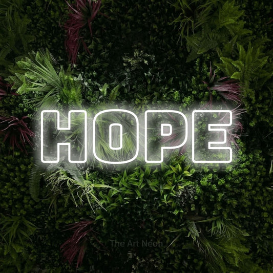 Cool white outline-style LED neon sign reading "Hope" against a lush garden wall with pink flowers