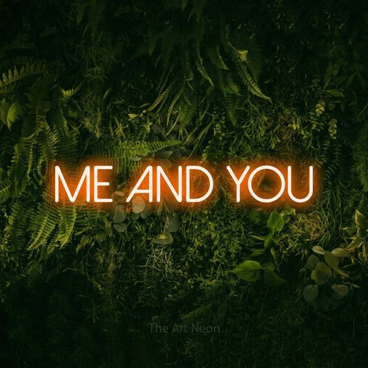 Orange LED neon sign reading "Me and You" against a moss-covered green wall