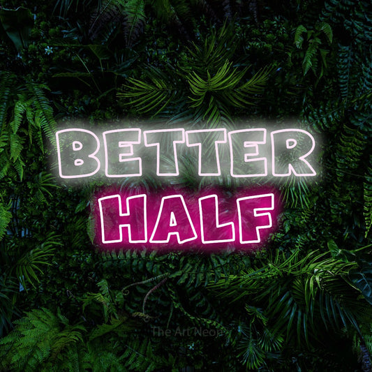 Hot pink and cool white outline-style LED neon sign reading "Better Half" against a dense tropical foliage wall
