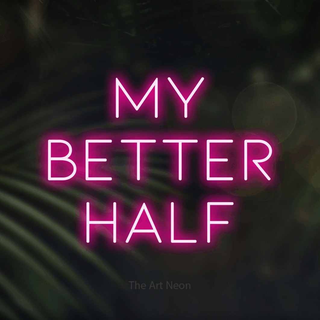 Hot pink LED neon sign reading "My Better Half" against dark blurred palm leaves