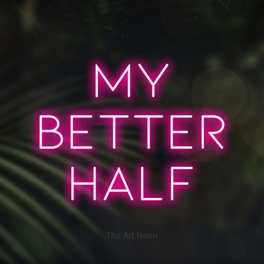 Hot pink LED neon sign reading "My Better Half" against dark blurred palm leaves