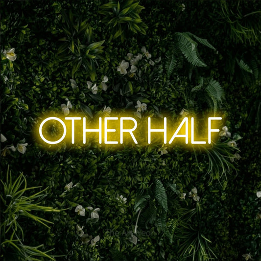 Yellow LED neon sign reading "Other Half" against a leafy green wall