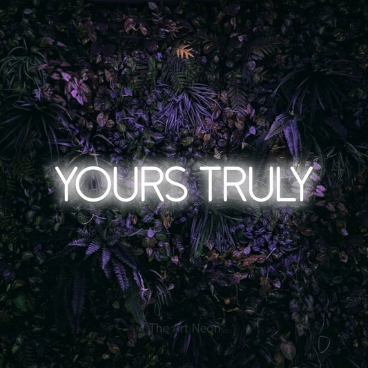 Cool white LED neon sign reading "Yours Truly" against a purple floral wall