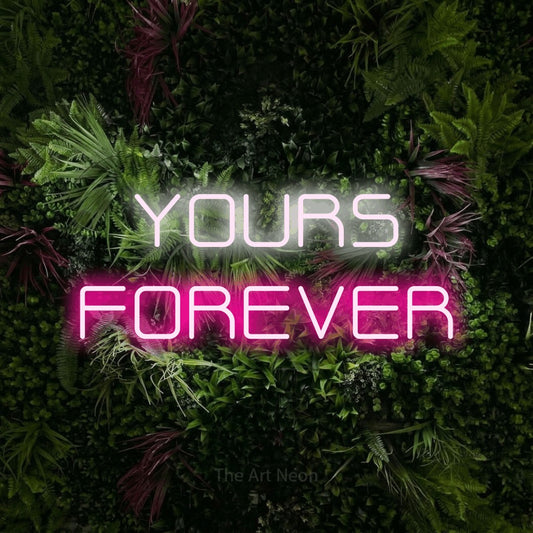 Hot pink and cool white LED neon sign reading "Yours Forever" against a lush garden wall with pink flowers