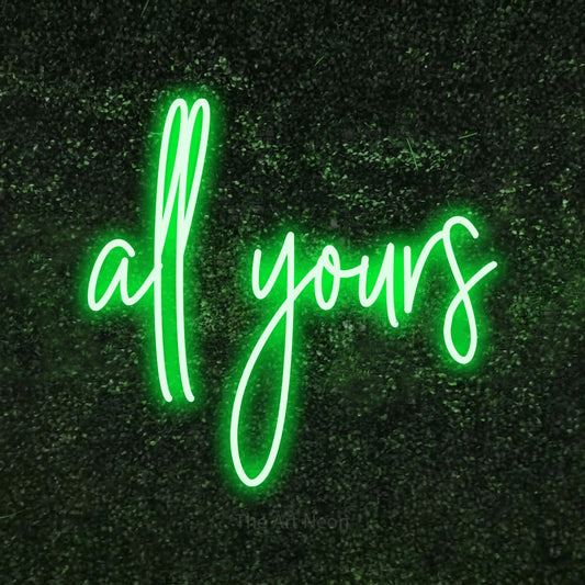 Green script-style LED neon sign reading "All Yours" against a textured green moss wall