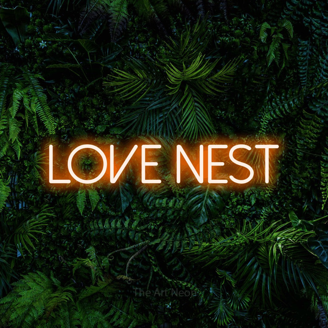 Enseigne néon à DEL à lumière orange, affichant « Love Nest » sur un mur de feuillage tropical dense
