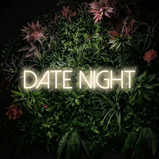 Warm white LED neon sign reading "Date Night" against a flowering garden wall