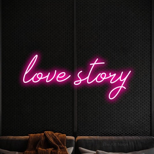 Hot pink script-style LED neon sign reading "Love Story" against a black textured wall