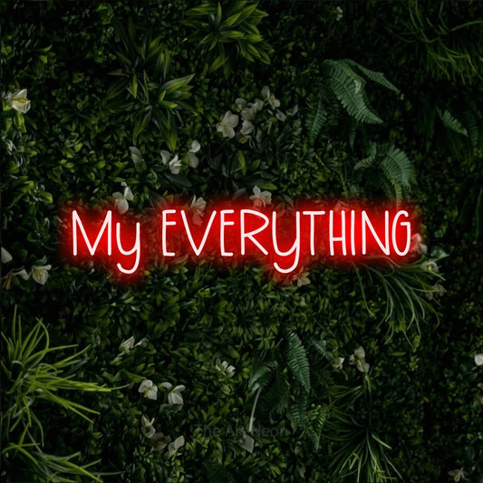 Red LED neon sign reading "My Everything" against a leafy green wall