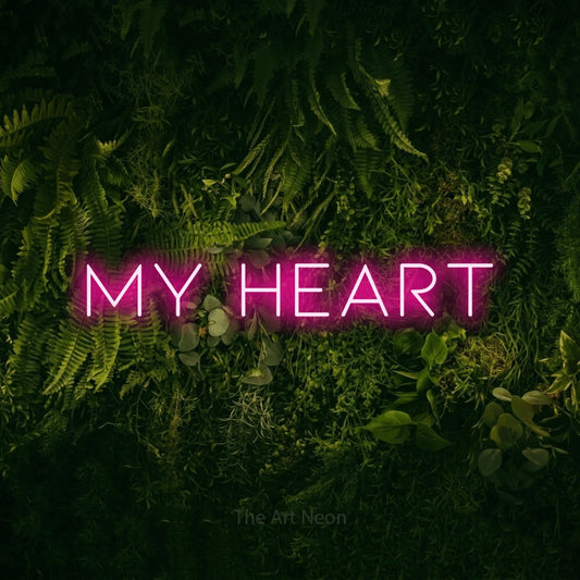 Hot pink LED neon sign reading "My Heart" against a moss-covered green wall