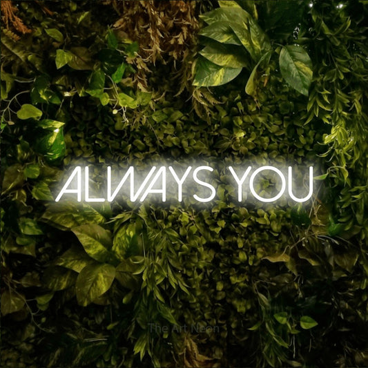 Cool white LED neon sign reading "Always You" against a textured moss and foliage wall