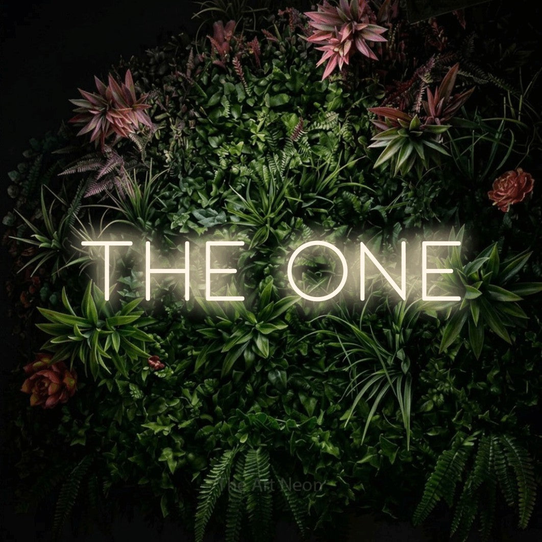 Warm white LED neon sign reading "The One" against a flowering garden wall