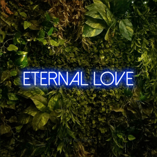 Blue LED neon sign reading "Eternal Love" against a textured moss and foliage wall
