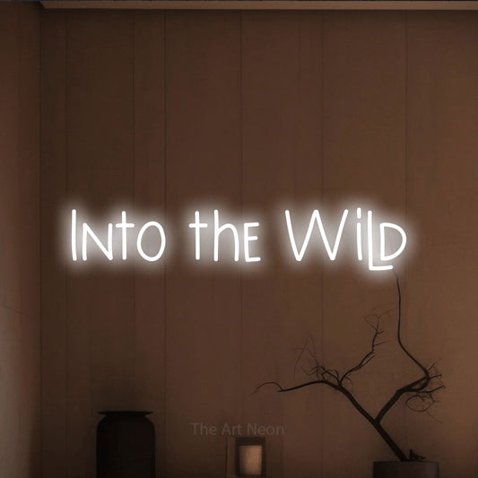 Cool white LED neon sign reading "Into the Wild" against a warm brown wall