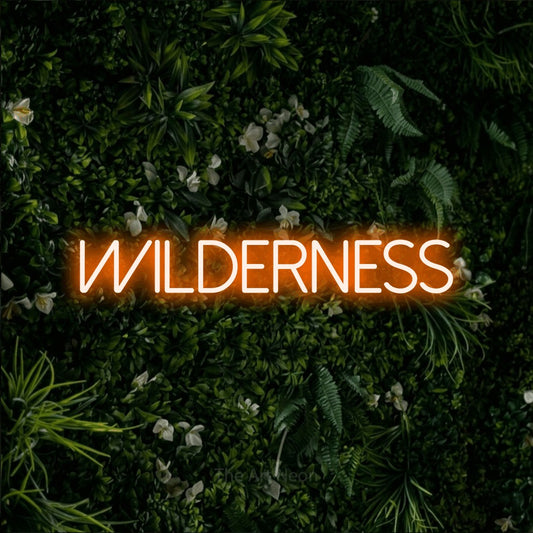 Orange LED neon sign reading "Wilderness" against a leafy green wall
