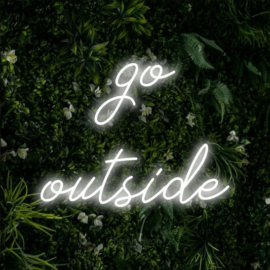 Cool white script-style LED neon sign reading "Go Outside" against a leafy green wall