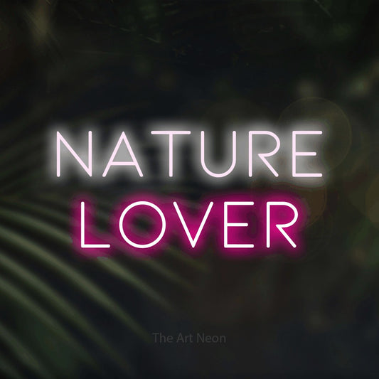 Hot pink and cool white LED neon sign reading "Nature Lover" against dark blurred palm leaves