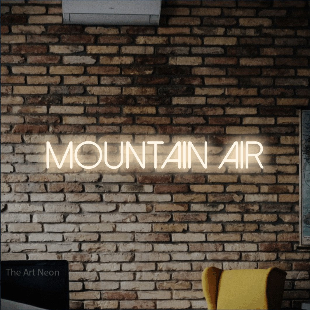 Warm white LED neon sign reading "Mountain Air" against a rustic brick wall