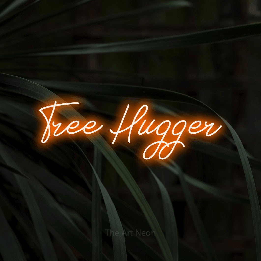 Orange script-style LED neon sign reading "Tree Hugger" against dark tropical leaves
