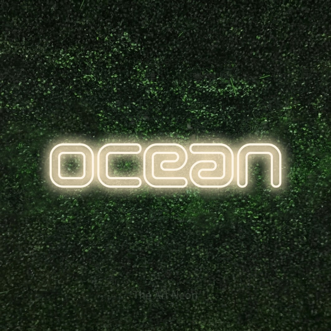 Enseigne néon à DEL à lumière blanche chaude, de style contour, affichant « Ocean » sur un mur texturé de mousse verte