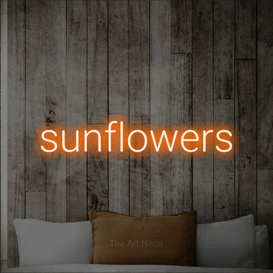 Orange LED neon sign reading "Sunflowers" against a whitewashed wooden wall