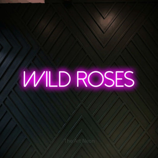 Pink LED neon sign reading "Wild Roses" against a dark geometric wood wall