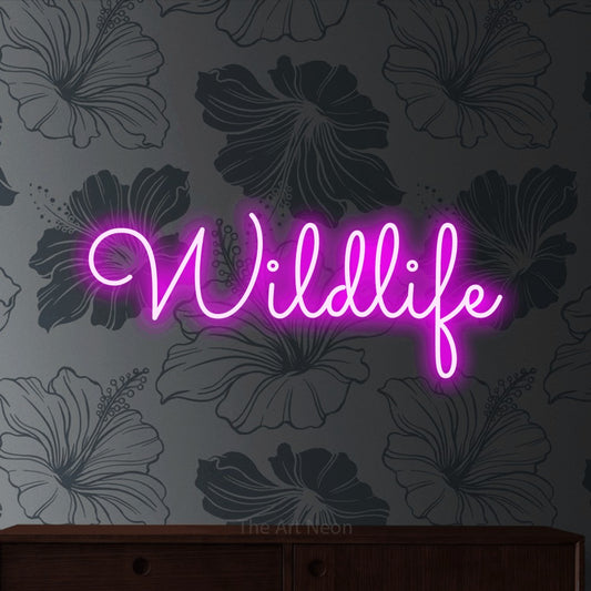 Pink LED neon sign reading "Wildlife" against grey floral wallpaper