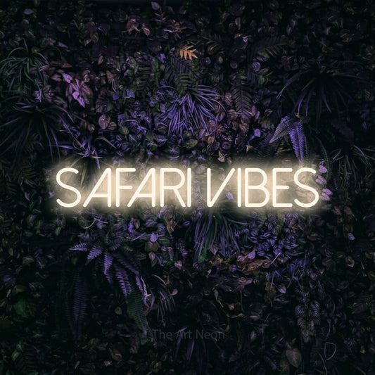 Warm white LED neon sign reading "Safari Vibes" against a purple floral wall