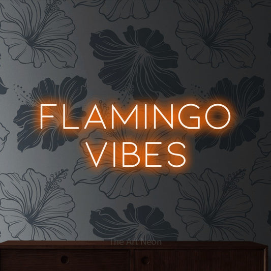 Orange LED neon sign reading "Flamingo Vibes" against grey floral wallpaper