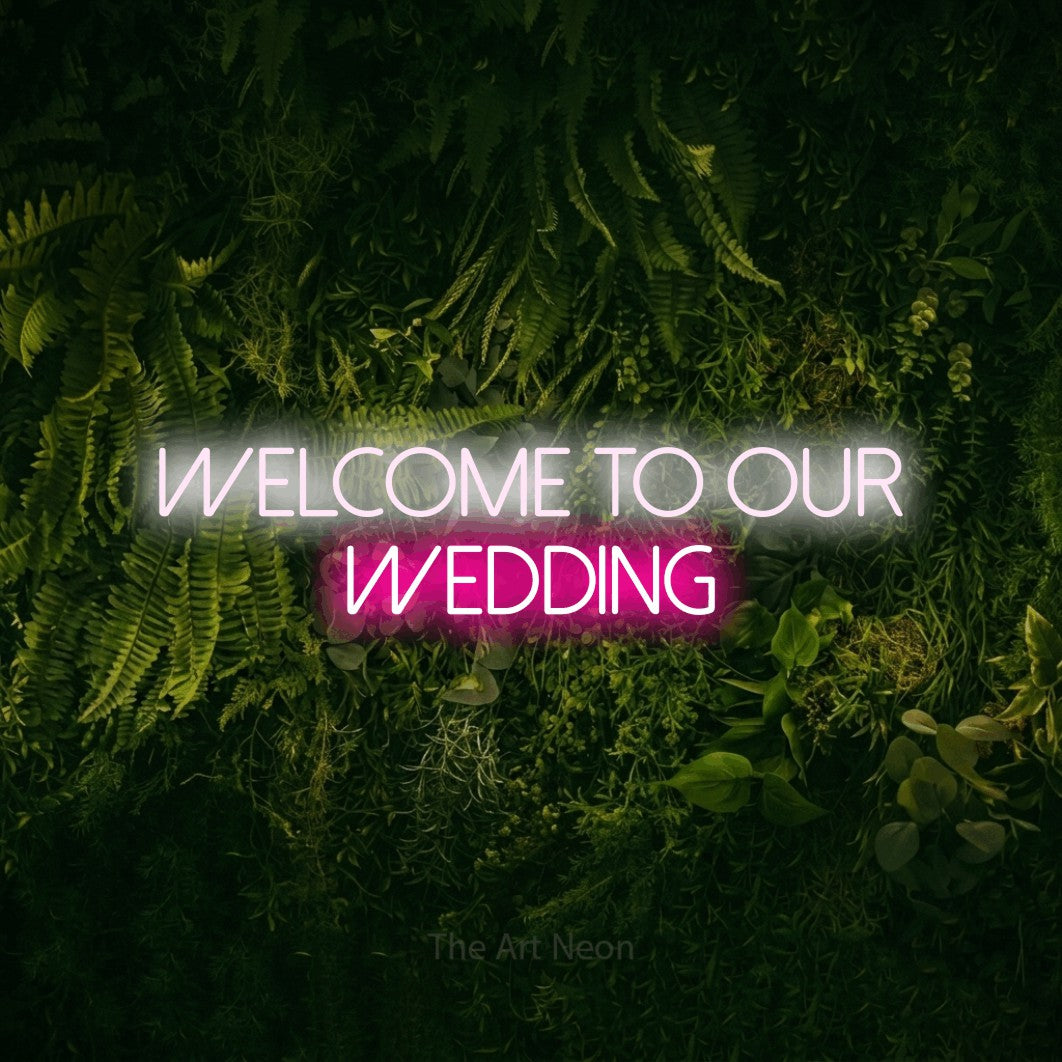 Hot pink and cool white LED neon sign reading "Welcome to Our Wedding" against a moss-covered green wall for wedding décor