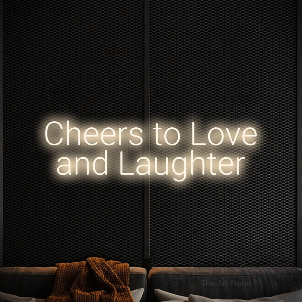Warm white LED neon sign reading "Cheers to Love and Laughter" against a black textured wall for wedding décor