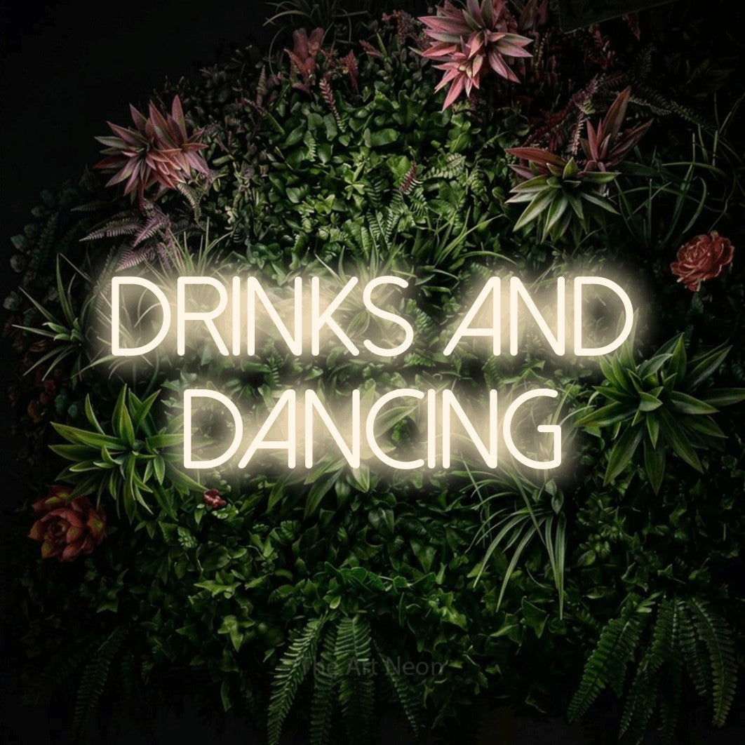 Warm white LED neon sign reading "Drinks and Dancing" against a flowering garden wall for wedding décor