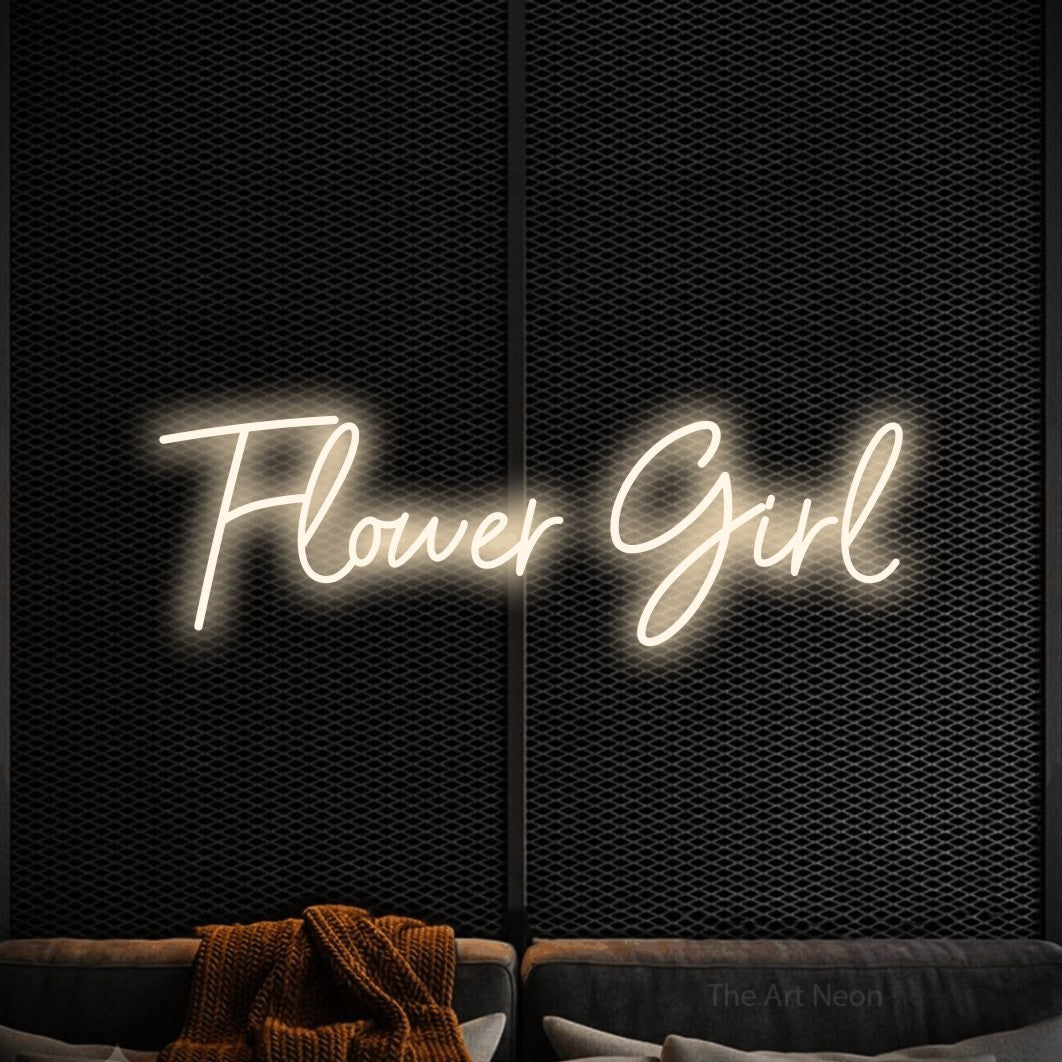Warm white script-style LED neon sign reading "Flower Girl" against a black textured wall for wedding décor