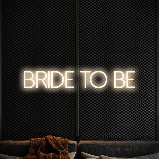 Warm white LED neon sign reading "Bride to Be" against a black textured wall for wedding décor