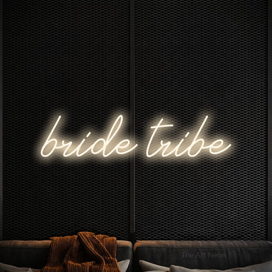 Warm white script-style LED neon sign reading "Bride Tribe" against a black textured wall for wedding décor