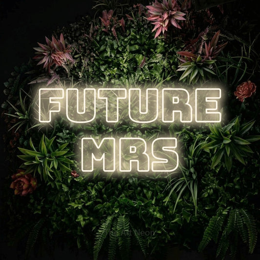 Warm white outline-style LED neon sign reading "Future Mrs" against a flowering garden wall for wedding décor