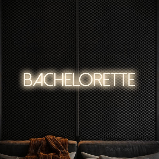 Warm white LED neon sign reading "Bachelorette" against a black textured wall for wedding décor