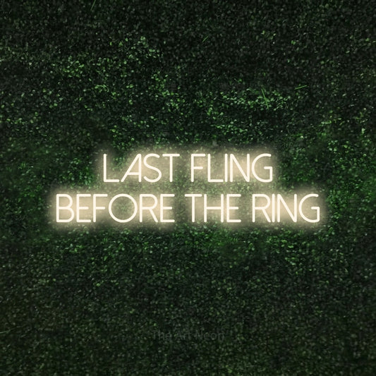 Warm white LED neon sign reading "Last Fling Before the Ring" against a textured green moss wall for wedding décor