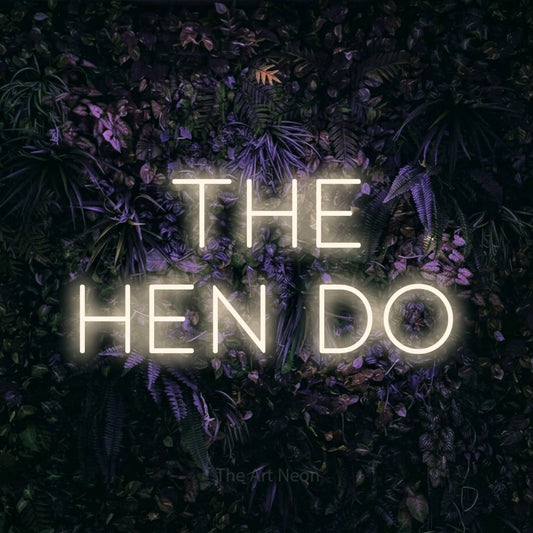 Warm white LED neon sign reading "The Hen Do" against a purple floral wall for wedding décor