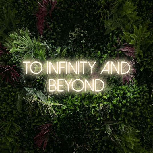 Warm white LED neon sign reading "To Infinity and Beyond" against a lush garden wall with pink flowers for wedding décor