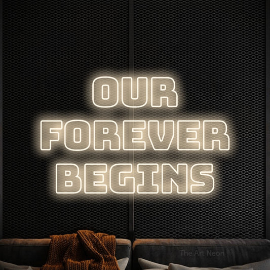 Warm white outline-style LED neon sign reading "Our Forever Begins" against a black textured wall for wedding décor